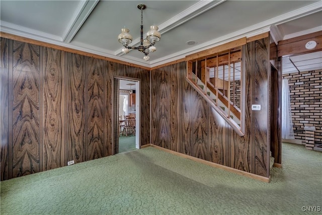 427 S James St, Wilna, NY 13619 - carpeted spare room with ornamental molding, wooden walls, and a notable chandelier