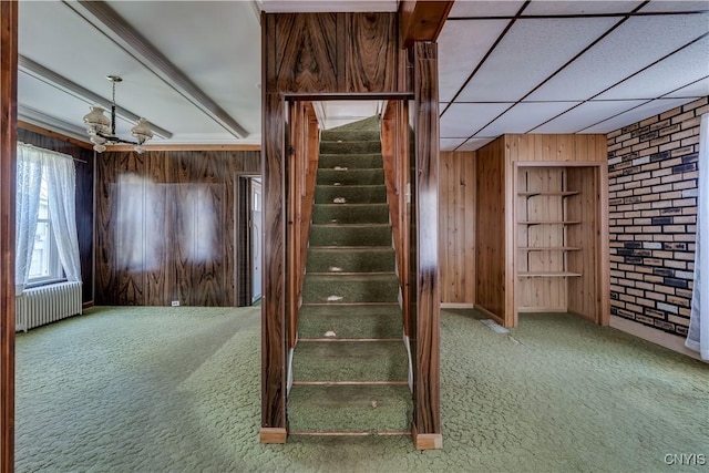 427 S James St, Wilna, NY 13619 - stairs with an inviting chandelier, wood walls, radiator, built in shelves, and carpet