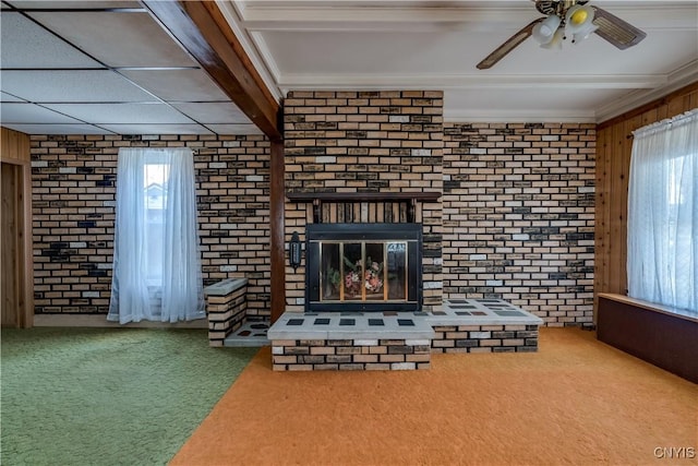 427 S James St, Wilna, NY 13619 - unfurnished living room featuring crown molding, ceiling fan, a brick fireplace, brick wall, and carpet