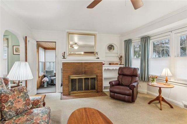 living room with carpet floors, a ceiling fan, crown molding, and visible vents