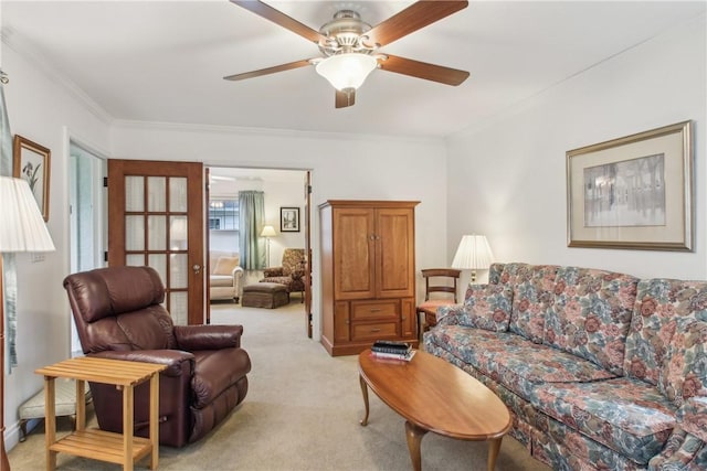 living room featuring crown molding, ceiling fan, and light carpet