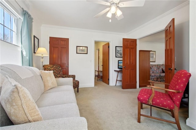 living room with baseboards, ceiling fan, ornamental molding, and light colored carpet