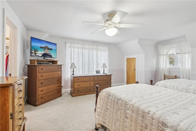 bedroom featuring baseboards, a ceiling fan, light carpet, and multiple windows
