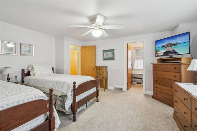 bedroom featuring baseboards, ceiling fan, light carpet, and visible vents