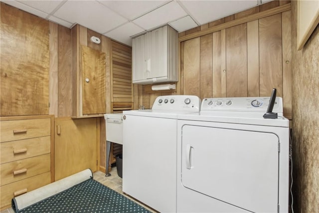 clothes washing area with separate washer and dryer and cabinet space