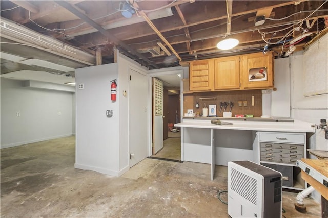 kitchen featuring baseboards, light countertops, and concrete floors