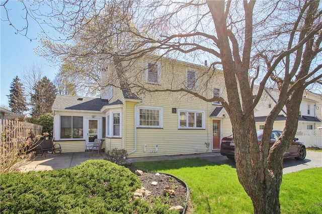 back of house featuring fence, a yard, and a patio area