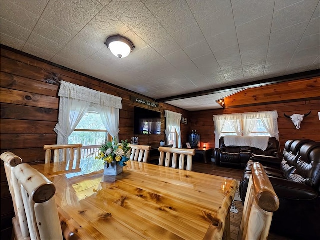 dining space featuring wood walls and wood finished floors