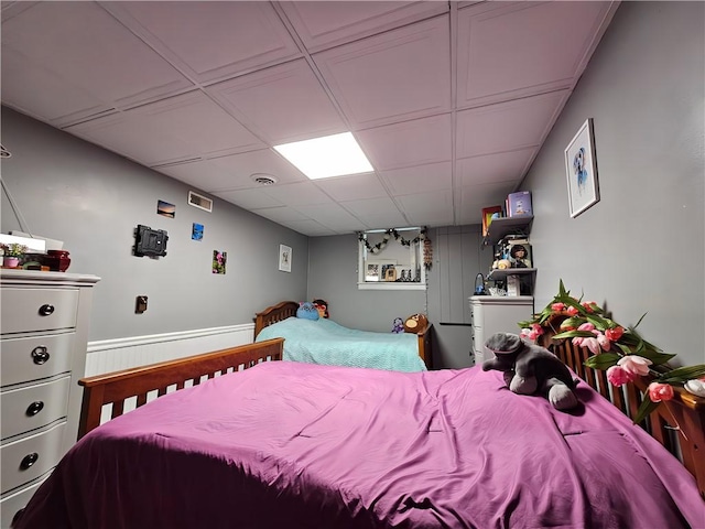 bedroom featuring a drop ceiling and visible vents