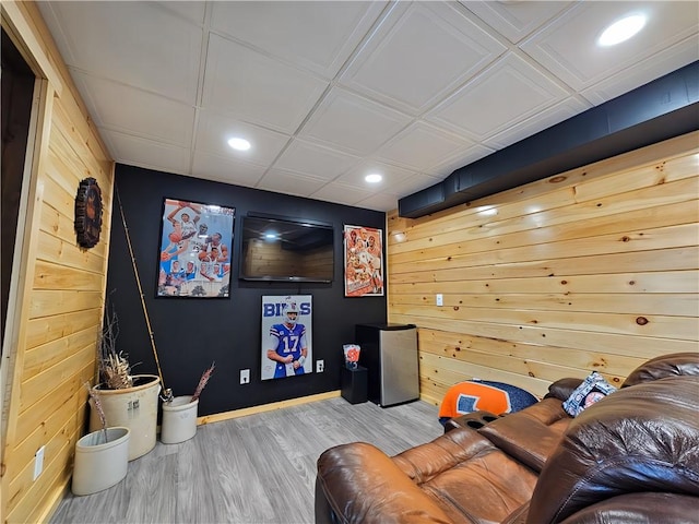 home theater room featuring wooden walls, baseboards, recessed lighting, and wood finished floors