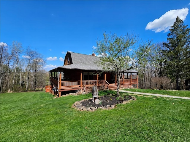 view of front of house with covered porch, a chimney, and a front yard