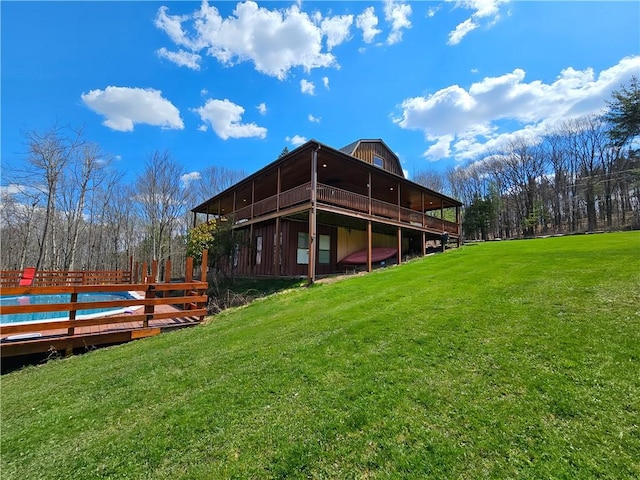 back of house featuring a wooden deck and a yard