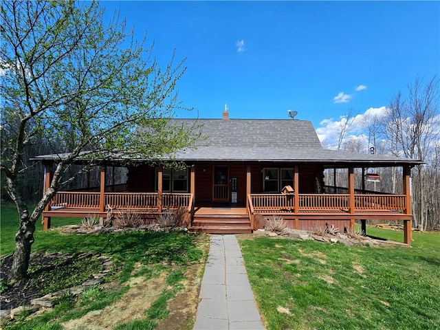 view of front of property with a shingled roof, a porch, and a front yard
