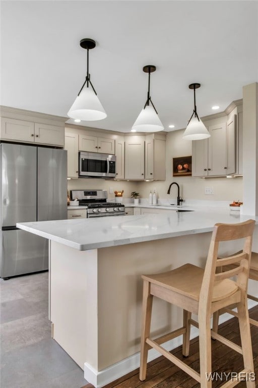 kitchen with a kitchen bar, pendant lighting, open shelves, a sink, and stainless steel appliances