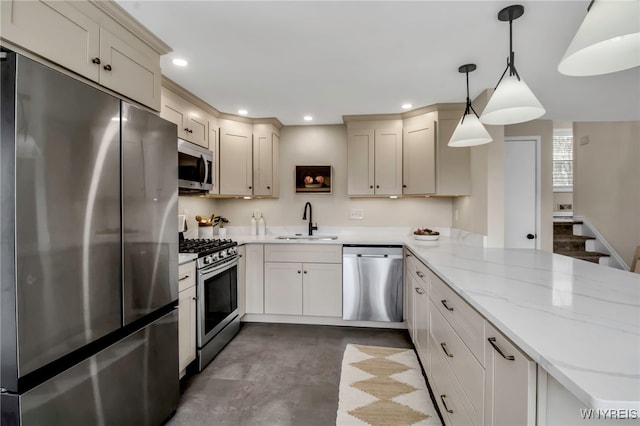 kitchen featuring a peninsula, light stone counters, a sink, appliances with stainless steel finishes, and decorative light fixtures