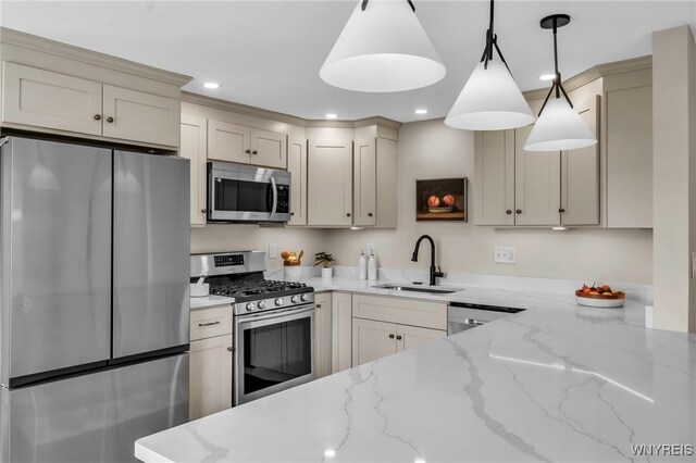 kitchen with decorative light fixtures, appliances with stainless steel finishes, a sink, light stone counters, and recessed lighting