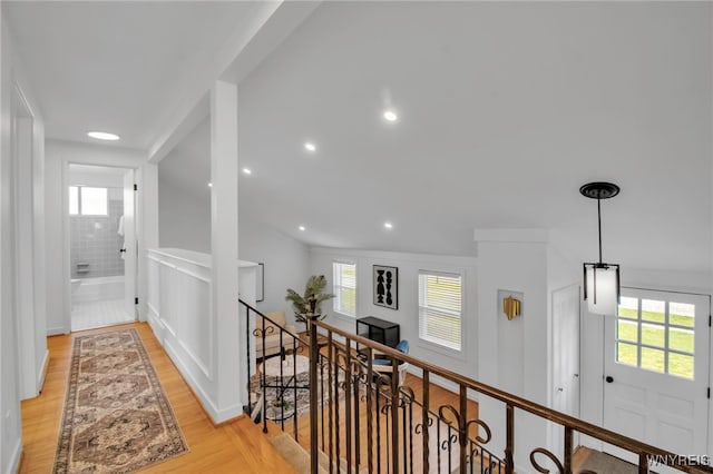 hall featuring a wealth of natural light, recessed lighting, light wood-style flooring, and an upstairs landing