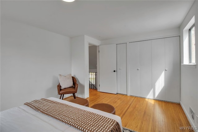 bedroom featuring two closets and wood finished floors