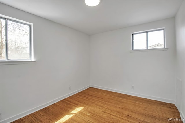 unfurnished room featuring baseboards and light wood finished floors