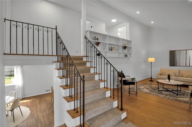 stairway with recessed lighting, baseboards, and wood finished floors