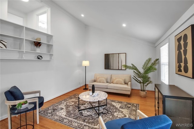 living area with recessed lighting, wood finished floors, and vaulted ceiling