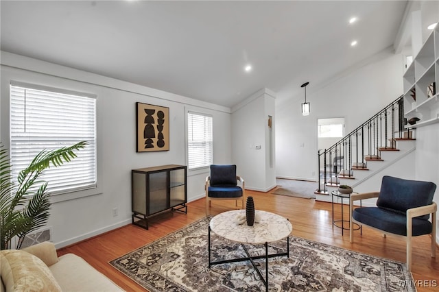 living area with vaulted ceiling, wood finished floors, stairway, baseboards, and recessed lighting