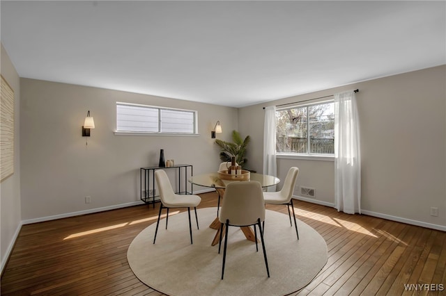 dining space with baseboards, wood-type flooring, and visible vents