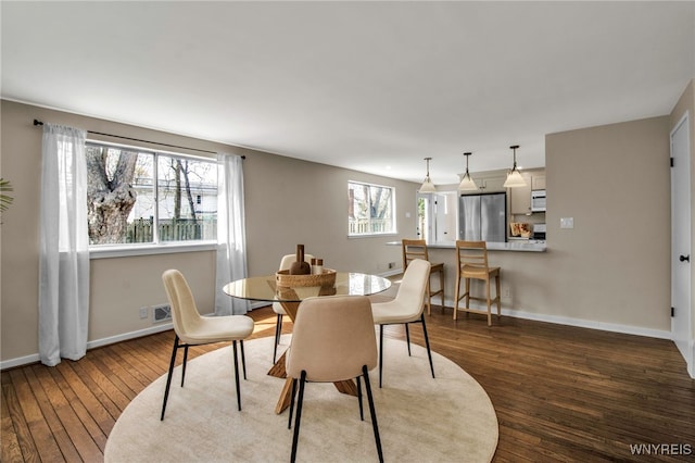 dining space featuring baseboards and hardwood / wood-style flooring
