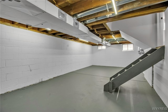 below grade area with stairs and concrete block wall