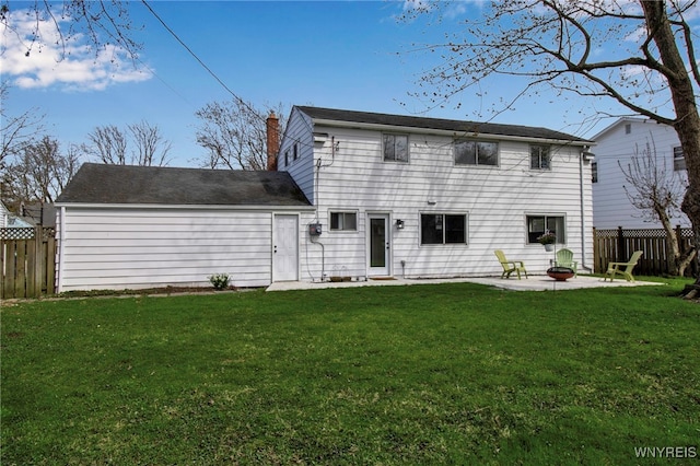 back of house with a lawn, a patio area, fence, and a chimney