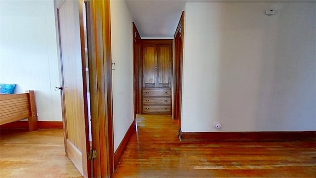 hallway featuring baseboards and wood finished floors