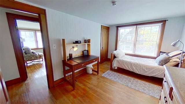 bedroom with light wood-type flooring and baseboards