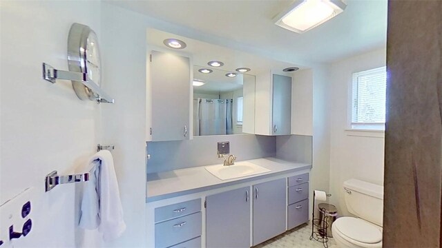 full bath featuring toilet, recessed lighting, and vanity
