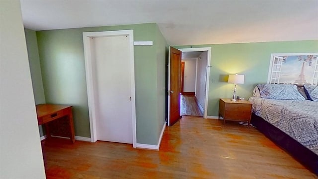 bedroom with baseboards and wood finished floors