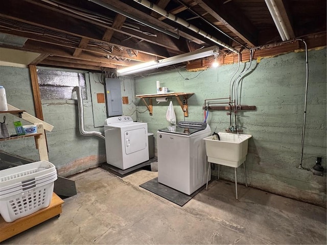 unfinished below grade area featuring a sink, electric panel, and washer and dryer