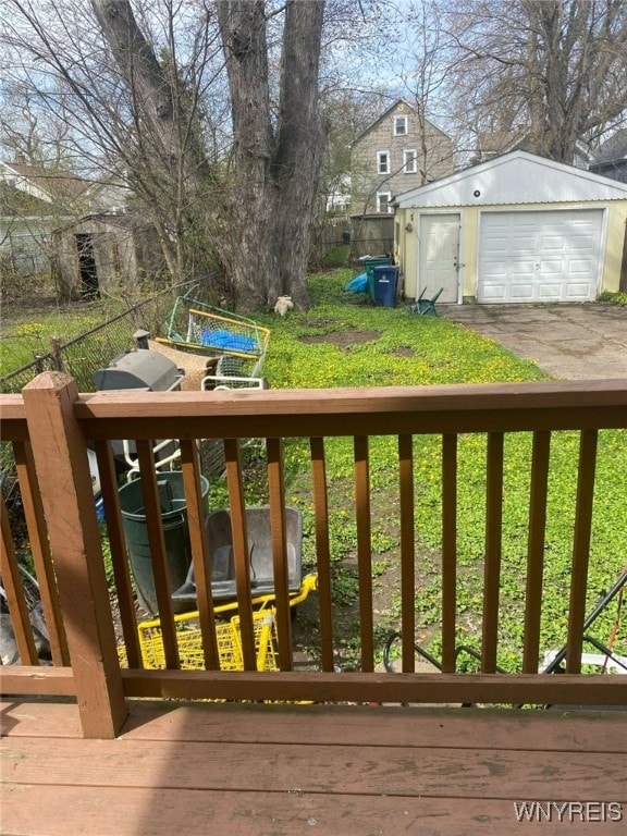 wooden deck with a garage, fence, and an outbuilding
