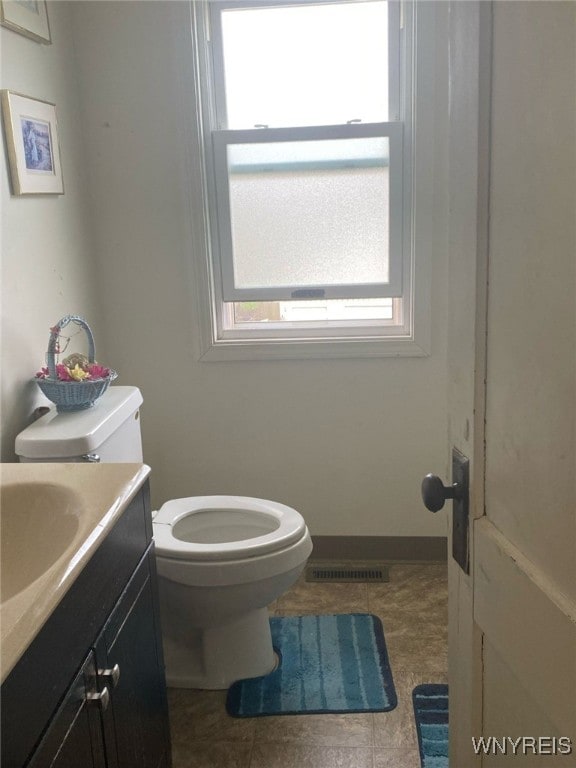bathroom featuring toilet, visible vents, tile patterned flooring, and vanity