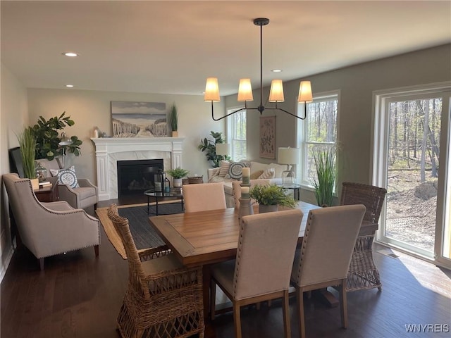 dining space featuring a fireplace, recessed lighting, and dark wood-style floors