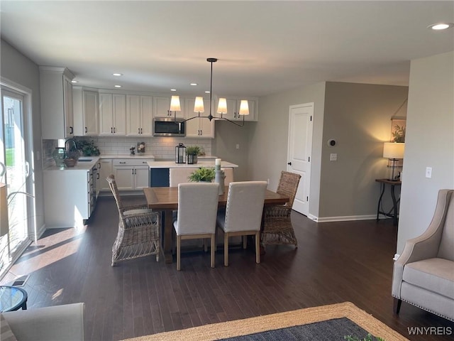 dining space with dark wood-style flooring, baseboards, recessed lighting, and a chandelier