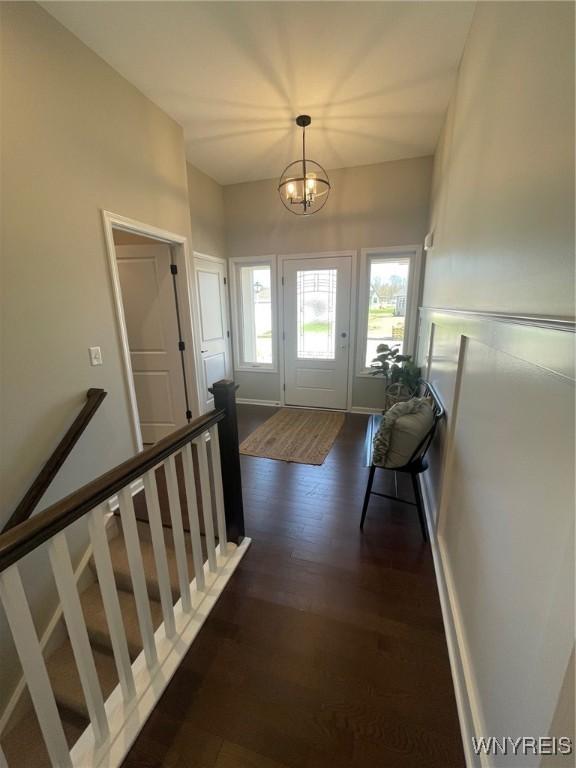 doorway featuring plenty of natural light, dark wood finished floors, and a notable chandelier