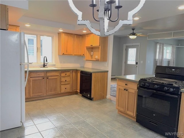kitchen with a sink, light countertops, ceiling fan with notable chandelier, recessed lighting, and black appliances