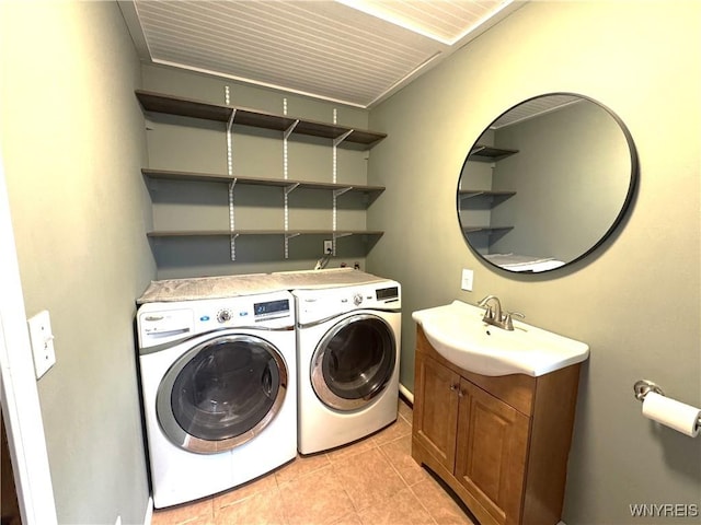 clothes washing area featuring separate washer and dryer, laundry area, light tile patterned flooring, and a sink