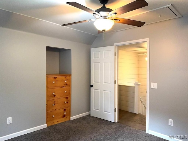 unfurnished bedroom featuring baseboards, a ceiling fan, attic access, and dark carpet