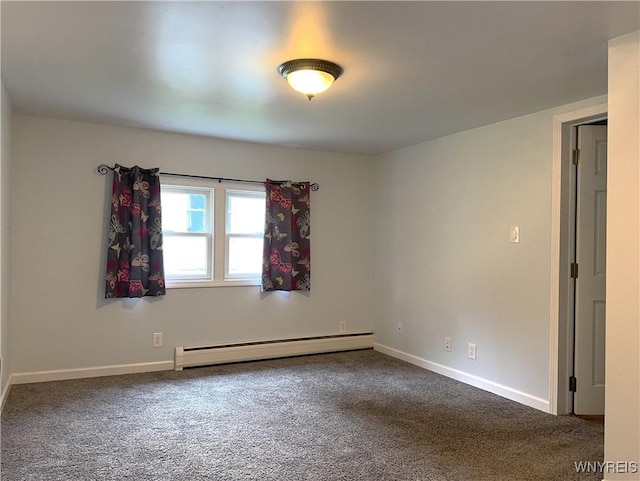spare room with dark colored carpet, a baseboard radiator, and baseboards