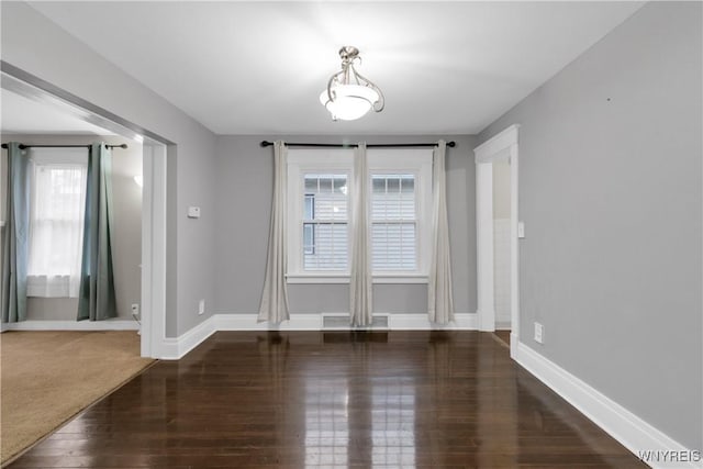 unfurnished dining area with baseboards and wood finished floors