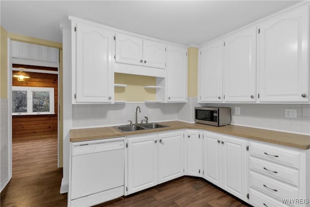 kitchen with decorative backsplash, dishwasher, a sink, stainless steel microwave, and dark wood-type flooring