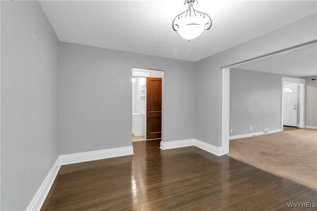 empty room with baseboards and wood finished floors