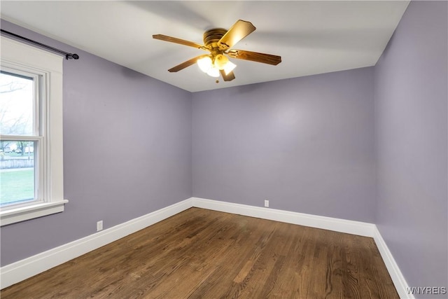 spare room featuring baseboards, ceiling fan, and wood finished floors