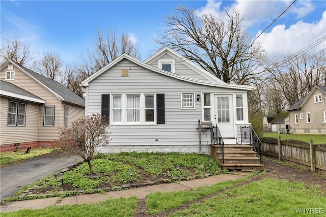 bungalow-style home with fence and entry steps