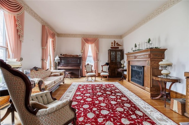 living area with a glass covered fireplace, wood finished floors, and a wealth of natural light